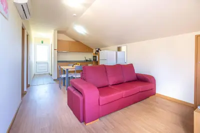 a living room with a pink couch and a kitchen at Quinta Frizado in Prazeres