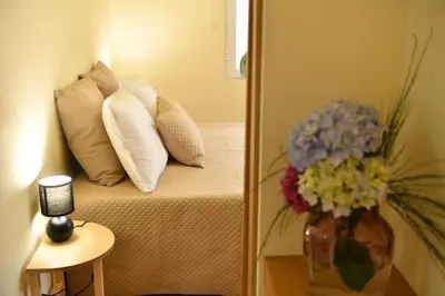 a room with a bed with pillows and a vase of flowers at Quinta Frizado in Prazeres