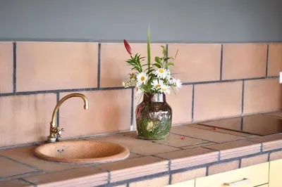 a vase of flowers sitting next to a sink at Quinta Frizado in Prazeres