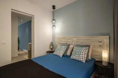 a bedroom with a blue bed with two pillows at BAYLEAF Apartments - Apartamento do Tempo in Funchal