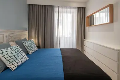 a bedroom with a bed with blue sheets and a window at BAYLEAF Apartments - Apartamento do Tempo in Funchal