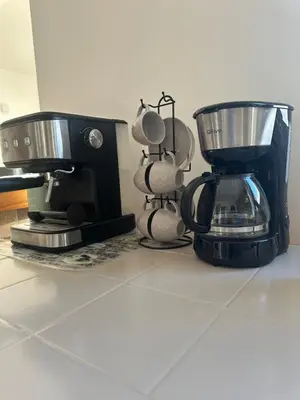a coffee maker and coffee cups on a counter at Luz Paradise in Luz