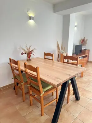 a wooden table and chairs in a living room at Luz Paradise in Luz