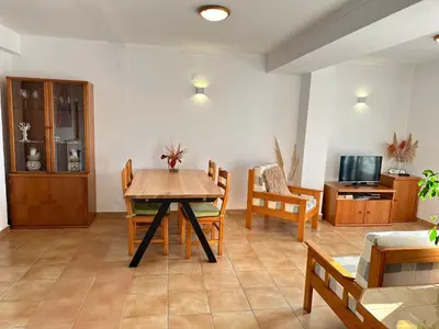 a living room with a wooden table and chairs at Luz Paradise in Luz