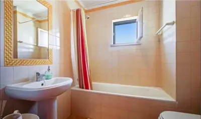 a bathroom with a sink and a tub and a toilet at Luz Paradise in Luz