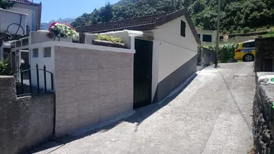 a white building with a door and flowers on it at A Casa da Avó... in São Vicente