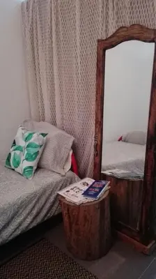a bedroom with a mirror and a bed and a table at A Casa da Avó... in São Vicente
