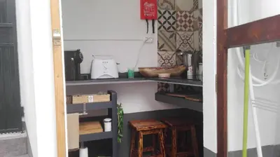 a room with a shelf with a blender and wooden stool at A Casa da Avó... in São Vicente