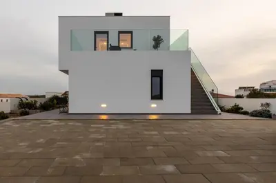 a white house with a staircase leading up to it at Biscuttela Vicentina in Praia da Arrifana