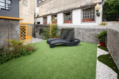 a garden with two chairs on a patch of grass at BAYLEAF Apartments - Casa D'Avó in Funchal