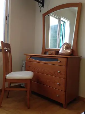 a dresser with a mirror on top of it with a chair at Bento Lodge by Madeira Holiday Rentals in Ribeira Brava