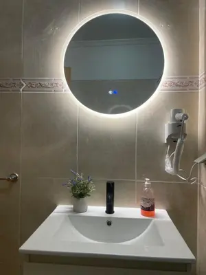 a bathroom with a sink with a round mirror at Bento Lodge by Madeira Holiday Rentals in Ribeira Brava