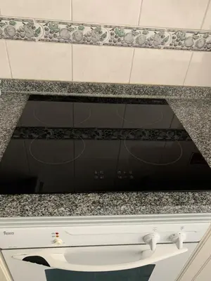a black dishwasher in a kitchen with granite counter tops at Bento Lodge by Madeira Holiday Rentals in Ribeira Brava