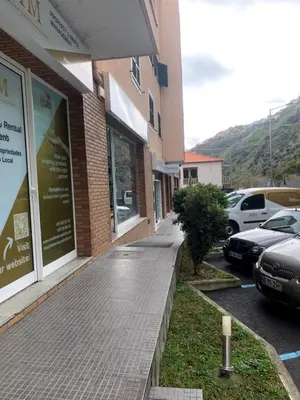 a sidewalk in front of a building with parked cars at Bento Lodge by Madeira Holiday Rentals in Ribeira Brava