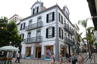 a white building with people walking in front of it at Edificio Charles 102 in Funchal