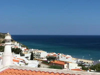 a view of a town with a lighthouse and the ocean at DOCEVIDA Appartement # Ocean View in Salema