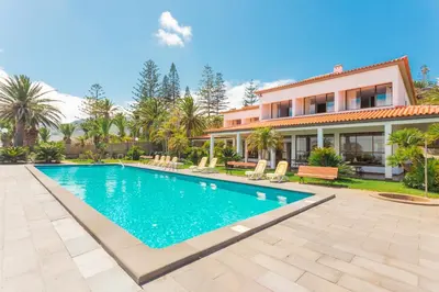a villa with a swimming pool in front of a house at FLH Luxury Villa Mar with Private Sea Access in Caniçal