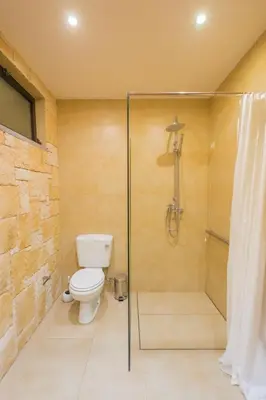 a bathroom with a toilet and a glass shower at FLH Luxury Villa Mar with Private Sea Access in Caniçal
