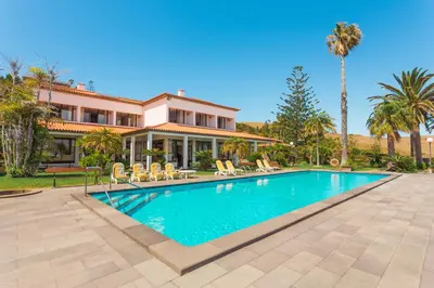 a house with a swimming pool and palm trees at FLH Luxury Villa Mar with Private Sea Access in Caniçal