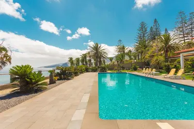 a swimming pool at a resort with palm trees at FLH Luxury Villa Mar with Private Sea Access in Caniçal