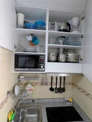 a kitchen with a sink and a microwave at Pereira Place in São Vicente