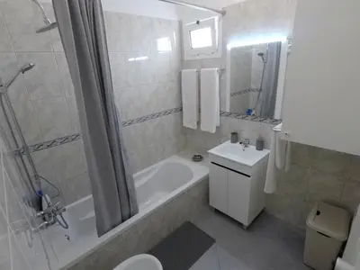 a bathroom with a tub and a toilet and a sink at Pereira Place in São Vicente