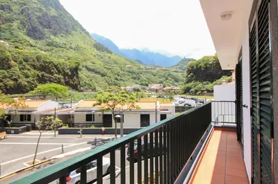 a balcony with a view of a street and mountains at Pereira Place in São Vicente