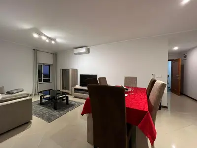 a dining room and living room with a red table and chairs at Villas Quinta da Lapa by AnaLodges in Câmara de Lobos