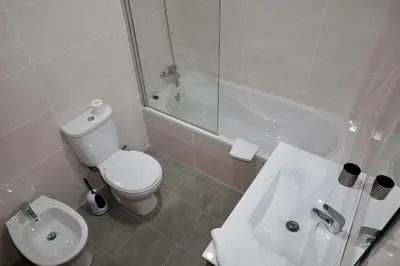 a bathroom with a toilet and a sink and a tub at Villas Quinta da Lapa by AnaLodges in Câmara de Lobos
