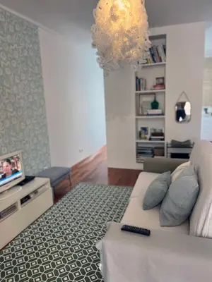 a living room with a couch and a television at Marias sea cottage in Funchal