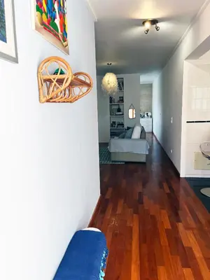 a living room with a blue couch and wooden floors at Marias sea cottage in Funchal