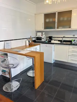 a kitchen with white cabinets and a wooden counter top at Marias sea cottage in Funchal
