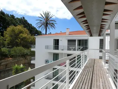 a balcony of a house with a palm tree in the background at Marias sea cottage in Funchal