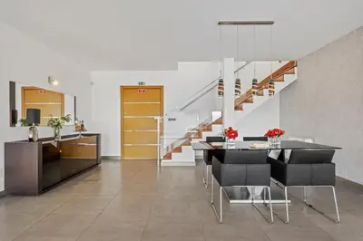a dining room with a table and chairs and a staircase at Villa Beausoleil by Homie in Funchal