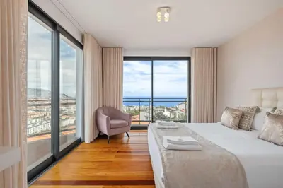 a bedroom with a bed and a large window at Villa Beausoleil by Homie in Funchal