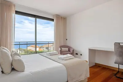 a bedroom with a bed and a large window at Villa Beausoleil by Homie in Funchal
