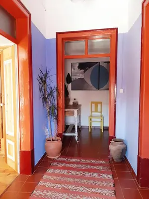 a hallway with blue and white walls and an orange door at Salmoura in Vila do Bispo