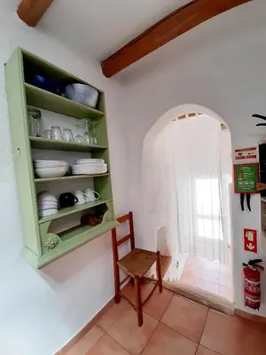 a kitchen with a green cabinet and a chair at Salmoura in Vila do Bispo
