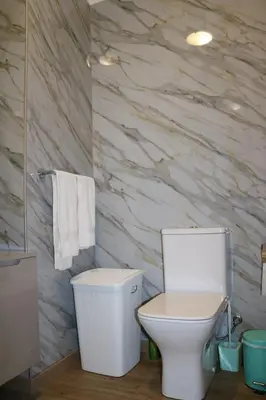 a bathroom with a white toilet and a stone wall at Uptown Madalenas in Funchal