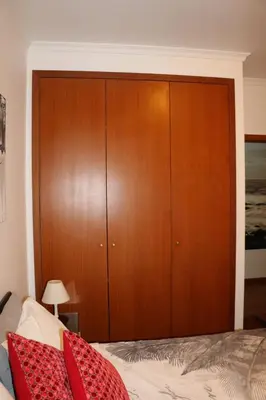 a bedroom with a large wooden cabinet next to a bed at Uptown Madalenas in Funchal