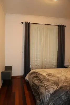 a bedroom with a bed and a window with curtains at Uptown Madalenas in Funchal