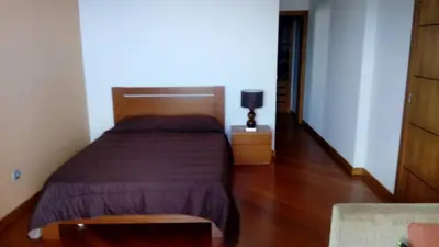 a bedroom with a bed and a wooden floor at Sea View House in Ribeira Brava