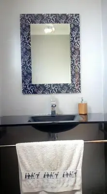 a bathroom with a sink with a mirror and a towel at Sea View House in Ribeira Brava