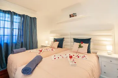 two beds in a bedroom with roses on them at Casa Lira in Arco da Calheta