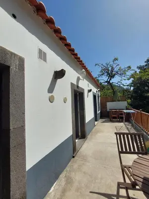 a white building with a door and a patio at casa da fajã in Funchal