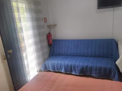 a blue couch in a room with a window at casa da fajã in Funchal