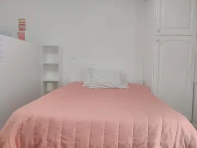 a bed with a pink comforter in a room at casa da fajã in Funchal