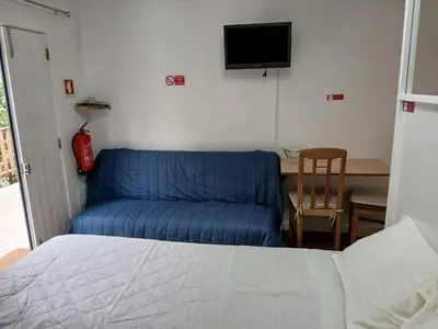 a living room with a blue couch and a table at casa da fajã in Funchal