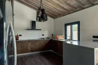 a kitchen with a table with chairs and a refrigerator at Quinta de São José in São Pedro