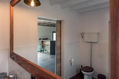 a bathroom with a mirror and a toilet at Quinta de São José in São Pedro